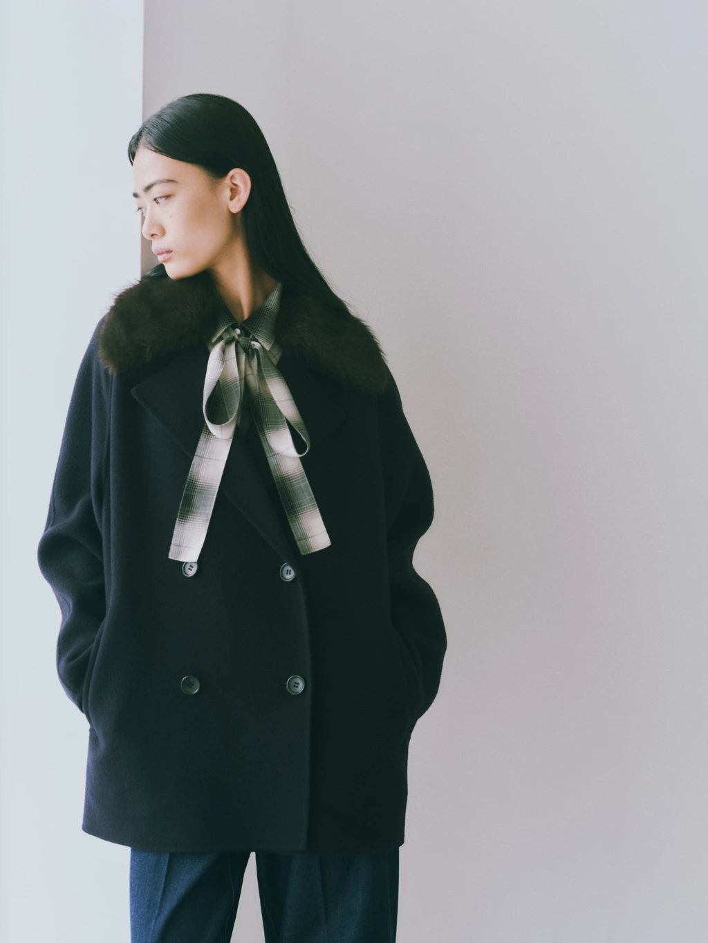 リボンタイを結んだチェック柄シャツと黒いショートコートの上半身カット